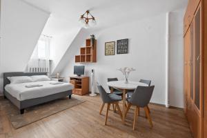 a bedroom with a bed and a table and chairs at Lublin Old Town Studio by BookingHost in Lublin