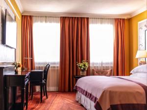 a hotel room with a bed and a desk and windows at Hotel Rotary Geneva - MGallery in Geneva +90 photos