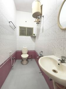 a bathroom with a toilet and a sink at Flickstays Hazel in Bangalore