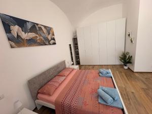 a bedroom with a bed and a painting on the wall at Home Albert-Lago Maggiore Luino in Luino
