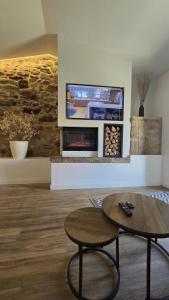 a living room with a fireplace and a tv at Casa rural Villa Quintans in Soutullo