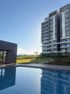 a swimming pool in front of two tall buildings at Spacious 2-Bedroom Family Suite with Pool & Garden View in Moka