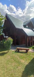 a wooden house with a bench in front of it at Kamp Bato in Brijeg