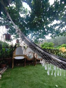 a hammock in a garden with a table and chairs at Casa da Maria Gata in Sever do Vouga