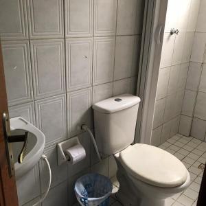 a small bathroom with a toilet and a trash can at Pousada e Restaurante Chateau Soneka in Algodoal