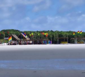 a group of colorful flags on a beach at Pousada e Restaurante Chateau Soneka in Algodoal