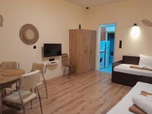 a living room with a bed and a table and a television at Leni in Ierissos