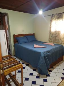 a bedroom with a blue bed and a chair at Pousada e Restaurante Chateau Soneka in Algodoal