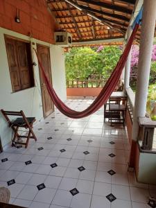 a porch with a hammock in a house at Pousada e Restaurante Chateau Soneka in Algodoal