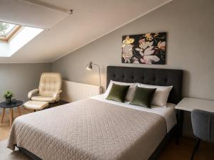 a bedroom with a large bed and a chair at KURESSAARE TALLINN STREET APARTMENTs in Kuressaare