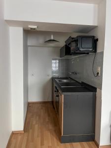 a kitchen with a sink and a tv on the wall at Mocafe Schloßbleiche in Wuppertal