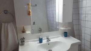a bathroom with a white sink and a mirror at The Village Corner in Politika +49 photos