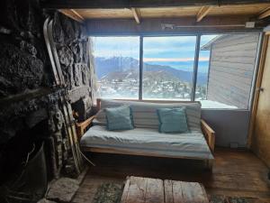 a bed in a room with a large window at Cordillera Hostel in Farellones