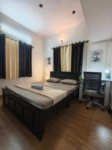 a bedroom with a bed and a desk and a chair at Flickstays Hazel in Bangalore