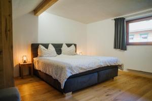 a bedroom with a bed and a window at Nockventure Ferienhaus Gnesau in Gnesau