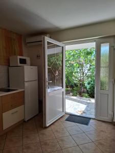 a kitchen with a refrigerator and a sliding glass door at Apartments Nada in Selce