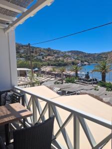 a balcony with tables and chairs and a view of the ocean at Sunset Hotel Kini Beachside in Kini