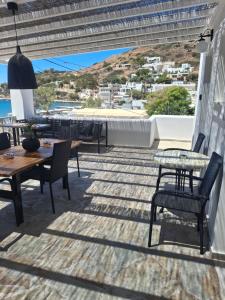 a patio with tables and chairs and a view of the ocean at Sunset Hotel Kini Beachside in Kini