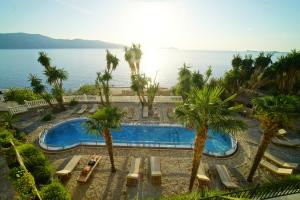 a view of a pool with palm trees and the ocean at Hotel Sanremo Vlore in Vlorë
