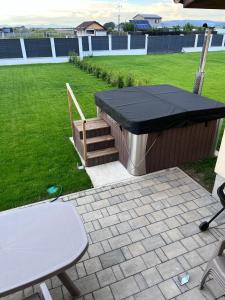 a barbecue with a black cover and a table and chairs at Casa Bella in Sînpetru