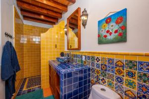 a bathroom with a toilet and a painting on the wall at La Sagrada in Guanajuato