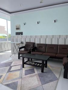 a living room with a couch and a coffee table at Ege Inn in Guraidhoo
