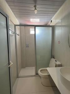 a bathroom with a shower and a toilet and a sink at Ege Inn in Guraidhoo