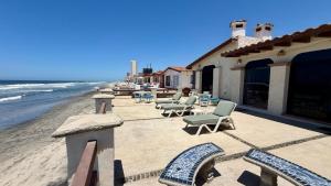 a patio with chairs and tables on the beach at Baja Del Mar 47 in Rosarito Beach