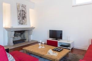 a living room with a table and a fireplace at Park View Central Apartment in Cascais in Cascais