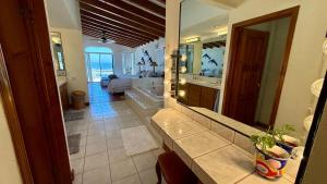 a bathroom with a large mirror and a bedroom at Baja Del Mar 47 in Rosarito Beach +38 photos
