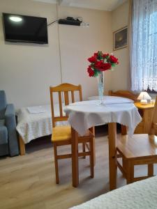 a room with a table with a vase of roses on it at EMAR in Karpacz