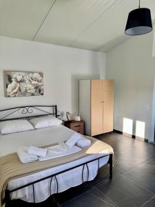 a bedroom with a large bed with towels on it at Villa Alonia House in Kallithéa
