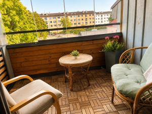 a balcony with chairs and a table and a window at KURESSAARE TALLINN STREET APARTMENTs in Kuressaare