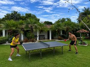 a man and woman playing a game of ping pong at Villa de lujo a 20 mins Buga con Piscina privada, Jacuzzi y BBQ in Guacarí