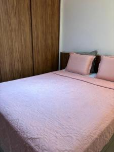 a pink bed with two pink pillows on it at Santos Unique 2701 Jacuzzi & Sea View Duplex in Santos +38 photos