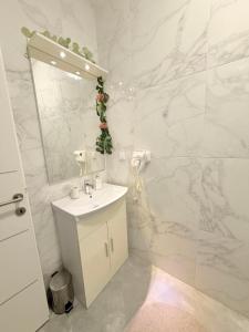 a white bathroom with a sink and a mirror at Lalya App in Vodnjan +10 photos