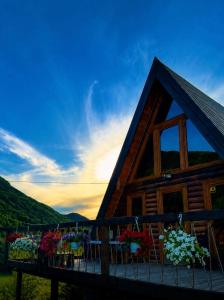 a cabin with a balcony with tables and flowers at Balic Inn in Gusinje +17 photos