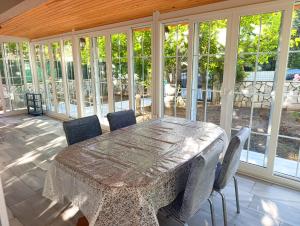 a dining room with a table and chairs and windows at Murat Kaptan Apt in Gündoğdu