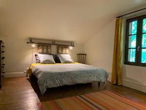 a bedroom with a bed with yellow sheets and a window at La Maison d'Ecluse No17 - Chambres d'hôtes in Castelsarrasin