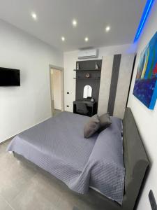 a bedroom with a large bed and a television at Le Perle di Aspra in Aspra