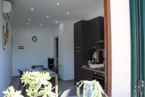 a room with a kitchen with a table and a mirror at Le Perle di Aspra in Aspra