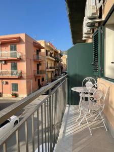 a balcony with a table and chairs on a building at Le Perle di Aspra in Aspra