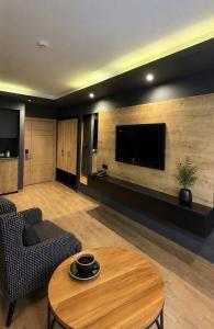 a living room with a table and a tv at Sezgin Hotel in Uzungöl