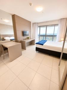 a bedroom with a bed and a desk and a tv at Alugueasy - Hotel Vision in Brasília +24 photos