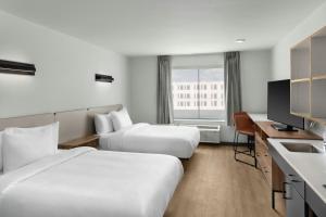 a hotel room with two beds and a television at StudioRes by Marriott Leland in Leland