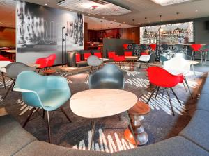 a restaurant with colorful chairs and tables in a room at ibis Gent Centrum Opera in Ghent