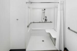 a white bathroom with a sink and a shower at StudioRes by Marriott Leland in Leland +40 photos