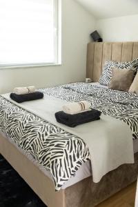 two beds with black and white sheets and pillows at Guest House Lejla in Travnik
