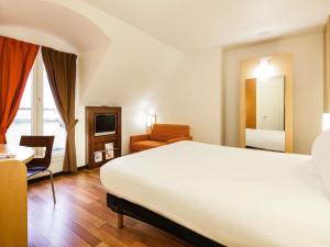a bedroom with a bed and a desk and a chair at ibis Versailles Château in Versailles +56 photos