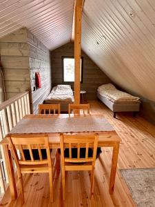a wooden table and chairs in a room with a bed at Sea Haven Villa in Trutberget